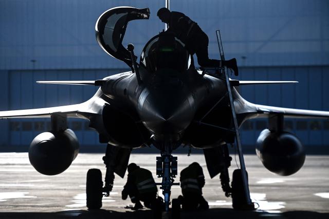 Ground staff perform pre-flight checks on a Rafale fighter jet ahead of a flight at a military air base during the Garuda 2025 French-Indian military cooperation exercise in Mont-de-Marsan, southwestern France, on November 26, 2025. (Photo by Christophe ARCHAMBAULT / AFP)