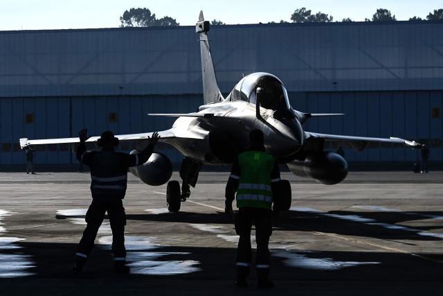 Ground staff help the French pilot of a Rafale fighter jet to its station following a flight at a military air base during the Garuda 2025 French-Indian military cooperation exercise in Mont-de-Marsan, southwestern France, on November 26, 2025. (Photo by Christophe ARCHAMBAULT / AFP)