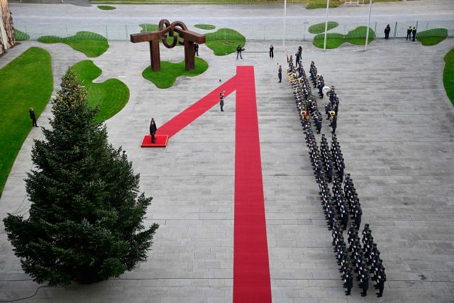Germany's Chancellor Friedrich Merz (on the podium, R) and Estonia's Prime Minister Kristen Michal (on the podium, L) review a military honor guard during an official welcome ceremony in front of the Chancellery in Berlin, Germany, on November 27, 2025. (Photo by John MACDOUGALL / POOL / AFP)