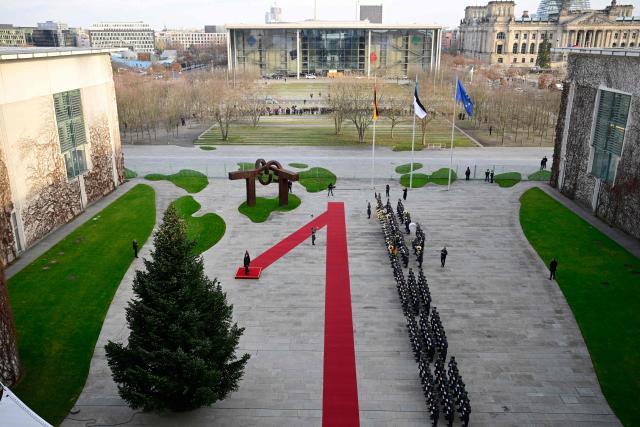 Germany's Chancellor Friedrich Merz (on the podium, R) and Estonia's Prime Minister Kristen Michal (on the podium, L) review a military honor guard during an official welcome ceremony in front of the Chancellery in Berlin, Germany, on November 27, 2025. (Photo by John MACDOUGALL / POOL / AFP)