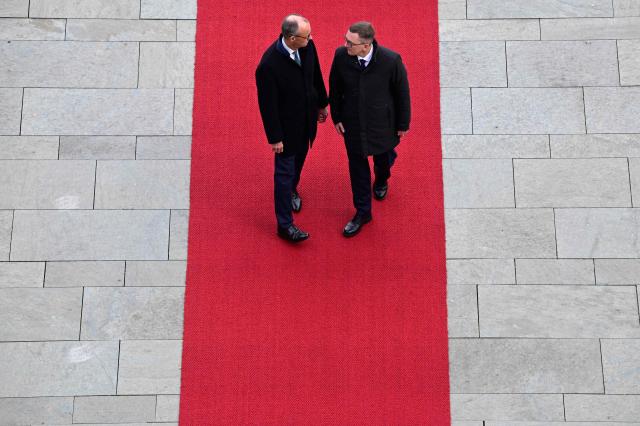 Germany's Chancellor Friedrich Merz (L) and Estonia's Prime Minister Kristen Michal review a military honor guard during an official welcome ceremony in front of the Chancellery in Berlin, Germany, on November 27, 2025. (Photo by John MACDOUGALL / POOL / AFP)