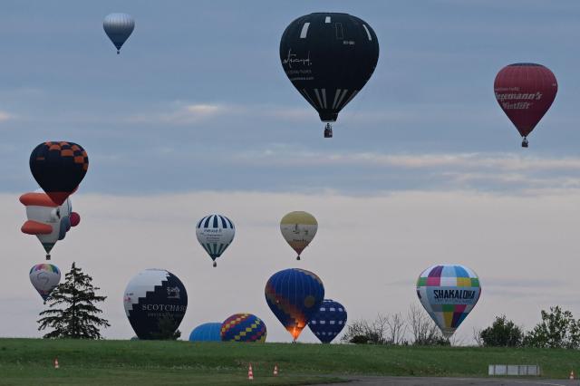 (FILES) Hot-air balloons fly over the Chambley-Bussieres air base in north-eastern France, during the first 'Enenvol' hot air balloon festival in Hageville, on July 28, 2025. It wanted to present the spectacle of hundreds of balloons in the sky, despite the cessation in 2023 of the Grand Est Mondial Air Ballons (GEMAB) in Chambley-Bussieres (Meurthe-et-Moselle): the EnEnvol festival confirmed to AFP on November 27, 2025 that it would not return in 2026, after only one edition. (Photo by Jean-Christophe VERHAEGEN / AFP)
