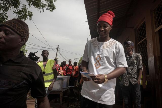 (FILES) Presidential candidate for the Social Renovation Party (PRS) Fernando Dias (C) carries ballot papers before casting his vote at a polling station in Mansoa on November 23, 2025, during Guinea-Bissau's presidential and legislative elections. (Photo by Samba BALDE / AFP)