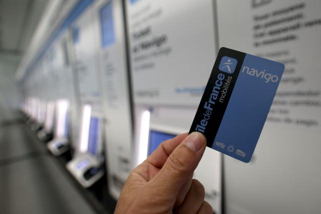 (FILES) This photograph shows a Navigo pass card with ticket booths at the Orly airport subway station during its unveiling, south of Paris, on June 19, 2024. Ile-de-France Mobilités (IDFM) is proposing a 2 euro increase in the price of the monthly Navigo pass, which will thus reach 90.80 euros from January 2026, the transport authority for the Ile-de-France region announced on November 27, 2025. (Photo by Emmanuel DUNAND / AFP)