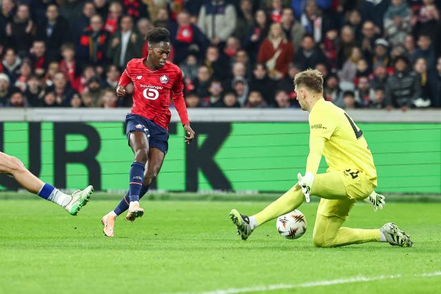 Lille's Portuguese forward #27 Felix Correia (L) scores his team's first goal past Dinamo Zagreb's Croatian goalkeeper #44 Ivan Filipovic (R) during the UEFA Europa League football match between Lille (LOSC) and GNK Dinamo Zagreb at the Pierre-Mauroy Stadium in Villeneuve-d'Ascq, northern France, on November 27, 2025. (Photo by Sameer Al-DOUMY / AFP)