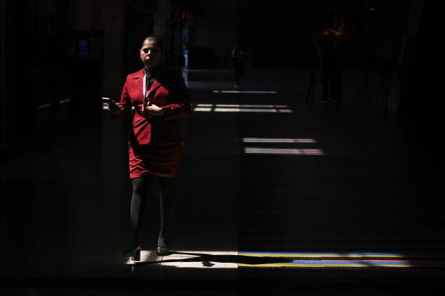 A flight attendant walk alongs an alley at Simon Bolivar International Airport in Maiquetia, La Guaira State, Venezuela, on November 27, 2025. Venezuela's decision to ban foreign airlines that stopped flying to the Caribbean country over concerns about US military activity was branded "disproportionate" on Thursday as thousands of passengers scrambled to save their travel plans. (Photo by Federico PARRA / AFP)