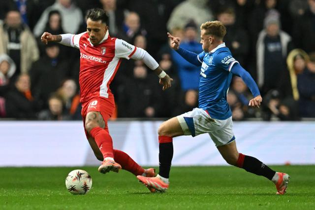 Rangers' Scottish midfielder #08 Connor Barron (R) vies with Sporting Braga's Uruguayan midfielder #10 Rodrigo Zalazar during the UEFA Europa League league-stage football match between Rangers and CS Braga at the Ibrox Stadium in Glasgow on November 27, 2025. (Photo by ANDY BUCHANAN / AFP)