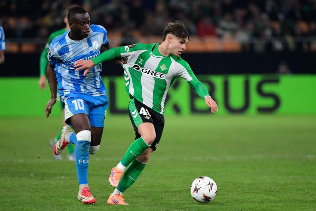 Real Betis' Spanish defender #40 Angel Ortiz (R) is tugged by FC Utrecht's French forward #10 Yoann Cathline during the UEFA Europa League first round football match between Real Betis and FC Utrecht at Benito Villamarin Stadium in Seville on November 27, 2025. (Photo by CRISTINA QUICLER / AFP)