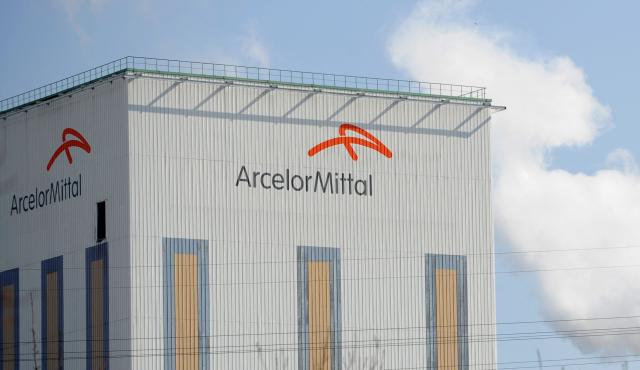 (FILES) A picture shows the logo of ArcelorMittal on a building in Florange during talks between the plant's management and union representatives at the sub-prefecture, on March 09, 2012 in Thionville, northeastern France. The National Assembly adopted on November 27, 2025 evening in first reading, by 127 votes against 41, a bill proposed by LFI aimed at nationalizing ArcelorMittal France, against the advice of the government which argues that the battle is being fought in Brussels. (Photo by Jean-Christophe VERHAEGEN / AFP)