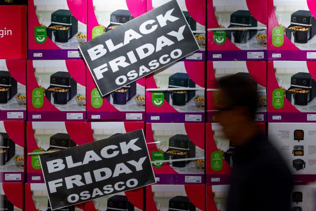 A man walks past Black Friday signs at a supermarket in Sao Paulo, Brazil on November 27, 2025. (Photo by Miguel SCHINCARIOL / AFP)