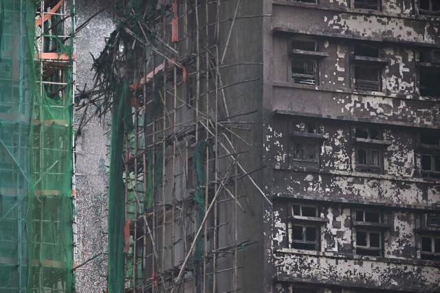 Damaged buildings are seen in the aftermath of a major fire that swept through several apartment blocks at the Wang Fuk Court residential estate in Hong Kong's Tai Po district on November 28, 2025. Hong Kong authorities said on November 28 the death toll from the city's worst fire in decades had risen to at least 94, with the blaze almost entirely extinguished and rescuers scouring torched high-rise buildings for scores of people still listed as missing. (Photo by Philip FONG / AFP)