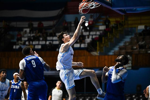 Argentina's Francisco Caffaro scores a basket past Cuba's Pedro Bombino (L) and Marlon Diaz (R) during the FIBA Basketball World Cup 2027 Americas qualifiers Group D match between Cuba and Argentina at the Ciudad Deportiva Coliseo in Havana on November 27, 2025. (Photo by YAMIL LAGE / AFP)