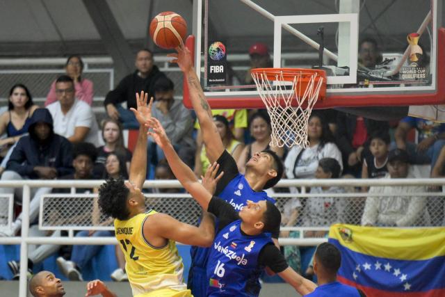 Venezuela's Windi Graterol (R) blocks Colombia's Jaime Echenique (L) during the FIBA Basketball World Cup 2027 Americas qualifiers Group C match between Colombia and Venezuela at the Coliseo Evangelista Mora in Cali, Colombia, on November 27, 2025. (Photo by Joaquín SARMIENTO / AFP)