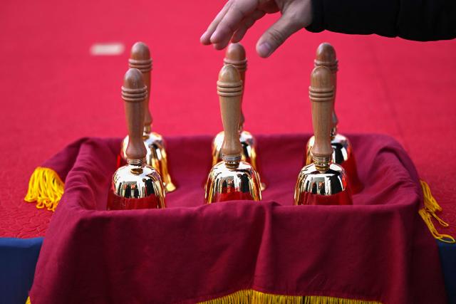 A Salvation Army officer picks up a bell during a ceremony to launch a year-end fundraising campaign of the Salvation Army at Gwanghwamun square in Seoul on November 28, 2025. (Photo by Jung Yeon-je / AFP)