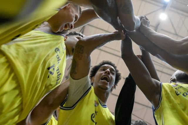 Colombia's Luiz Almanza and teammates celebrate after winning the FIBA Basketball World Cup 2027 Americas qualifiers Group C match between Colombia and Venezuela at the Coliseo Evangelista Mora in Cali, Colombia, on November 27, 2025. (Photo by Joaquín SARMIENTO / AFP)