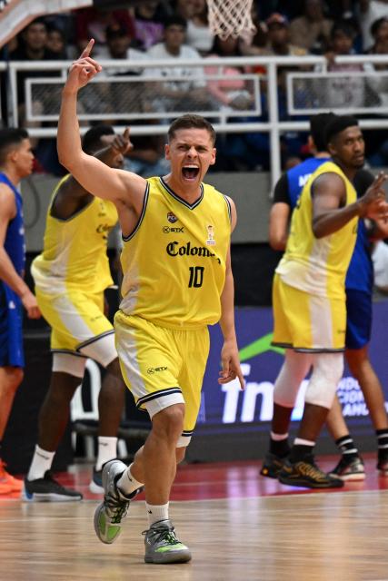 Colombia's Hansel Atencia celebrates scoring a basket during the FIBA Basketball World Cup 2027 Americas qualifiers Group C match between Colombia and Venezuela at the Coliseo Evangelista Mora in Cali, Colombia, on November 27, 2025. (Photo by Joaquín SARMIENTO / AFP)