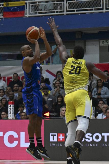 Venezuela's David Cubillan shoots the ball over Colombia's Andres Ibarguen during the FIBA Basketball World Cup 2027 Americas qualifiers Group C match between Colombia and Venezuela at the Coliseo Evangelista Mora in Cali, Colombia, on November 27, 2025. (Photo by Joaquín SARMIENTO / AFP)
