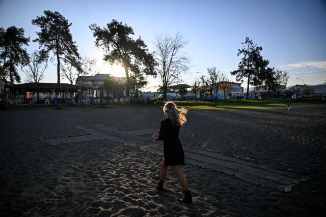 Spanish Irati Aguirre, 26, walks next to a cross she drew with stones on the beach as she waits for the arrival of Pope Leo XIV next to remains of the sunken Byzantine Basilica of the Holy Fathers on the shore of Lake Iznik, in Iznik, on November 28, 2025. Pope Leo XIV is on a four-day visit to Turkey. (Photo by Ozan KOSE / AFP)