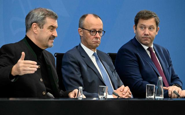 (L-R) Bavaria's State Premier and leader of the conservative Christian Social Union (CSU) Markus Soeder, German Chancellor Friedrich Merz and German Finance Minister, Vice-Chancellor and leader of the Germany's Social Democratic Party (SPD) Lars Klingbeil attend a press briefing on the results of the coalition committee consultations on the pensions package, on November 28, 2025 at the Chancellery in Berlin. (Photo by Tobias SCHWARZ / AFP)