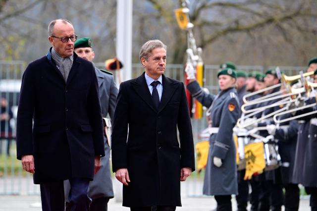 German Chancellor Friedrich Merz (L) and Slovenia's Prime Minister Robert Golob review a military honour guard during a welcoming ceremony on November 28, 2025 at the Chancellery in Berlin. (Photo by Tobias SCHWARZ / AFP)