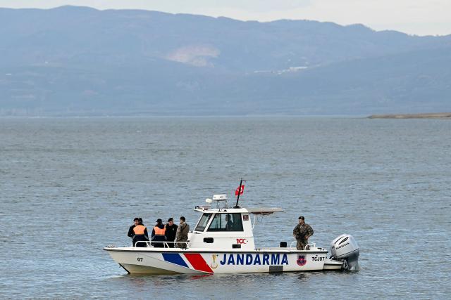 A Turkish gendarme boat secure the area next to police officers before the arrival of Pope Leo XIV to attend an ecumenical prayer service near the sunken Byzantine Basilica of Saint Neophytos by Lake Iznik, on November 28, 2025. Pope Leo XIV is on a four-day visit to Turkey. (Photo by OZAN KOSE / AFP)