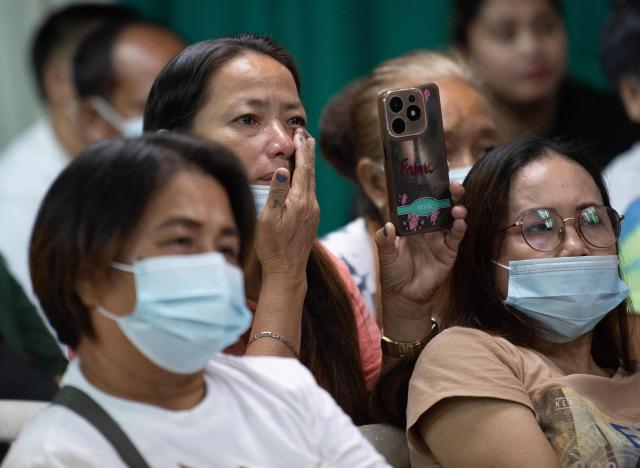 TOPSHOT - A relative (C) of one of the victims of extrajudicial killings wipes tears as she and others watch the live streaming of the hearing on the appeal ruling on the provisional release of former Philippine president Rodrigo Duterte, who is accused of crimes against humanity, at a religious house in Manila on November 28, 2025. (Photo by Ted ALJIBE / AFP)