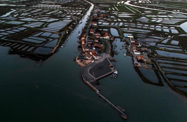 This aerial photograph shows "claires" or shallow oyster ponds along the River Seudre in Marennes, southwestern France, on November 18, 2025. Oyster farming is one of the main activities in coastal Charente Maritime where over 3000 hectares of oyster parks are located. Dating back from the 17th century, oyster farming developed fast when salt marshes were abandoned with the end of the salt's monetary role and turned into shellfish farming areas. Along the River Seudre, oysters's refining takes place in "claires" or shallow oyster ponds where fine fattening is carried out over periods of around 15 days in basins where salinity is controlled. (Photo by Christophe ARCHAMBAULT / AFP)