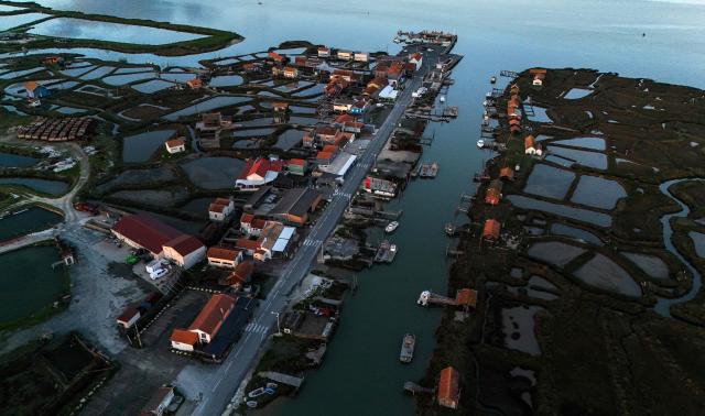 This aerial photograph shows "claires" or shallow oyster ponds along the River Seudre in La Tremblade, southwestern France, on November 18, 2025. Oyster farming is one of the main activities in coastal Charente Maritime where over 3000 hectares of oyster parks are located. Dating back from the 17th century, oyster farming developed fast when salt marshes were abandoned with the end of the salt's monetary role and turned into shellfish farming areas. Along the River Seudre, oysters's refining takes place in "claires" or shallow oyster ponds where fine fattening is carried out over periods of around 15 days in basins where salinity is controlled. (Photo by Christophe ARCHAMBAULT / AFP)