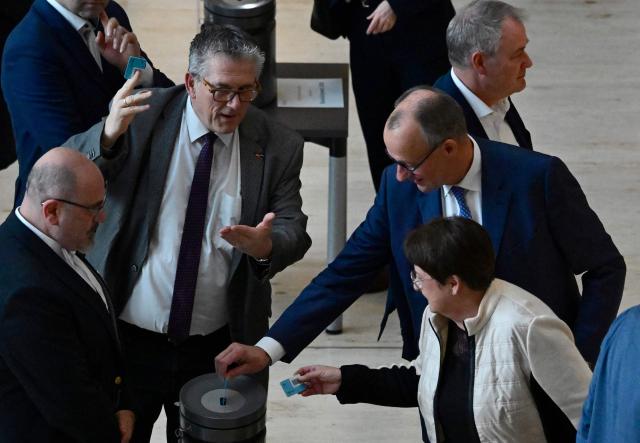 German Chancellor Friedrich Merz (R) casts his ballot for the federal budget 2026 during a debate on the 2026 federal budget at the Bundestag (lower house of parliament) on November 28, 2025 in Berlin. (Photo by John MACDOUGALL / AFP)