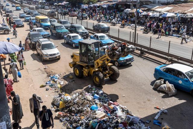 A backhoe collects garbage at a busy road in Bissau, on November 28, 2025. Life limped back to normal on Friday in the capital of volatile Guinea-Bissau after the west African nation's fifth coup that came on the heels of presidential and parliamentary polls.
The military appointed General Horta N'Tam, the army's chief of staff, as the country's new leader for a transition period of one year after Wednesday's putsch. The takeover came just one day before authorities had been due to announce the provisional results of the November 23 polls. There were vehicles and taxis along the main road from the port of the seaside capital Bissau to the presidential palace, as well as pedestrians (Photo by PATRICK MEINHARDT / AFP)