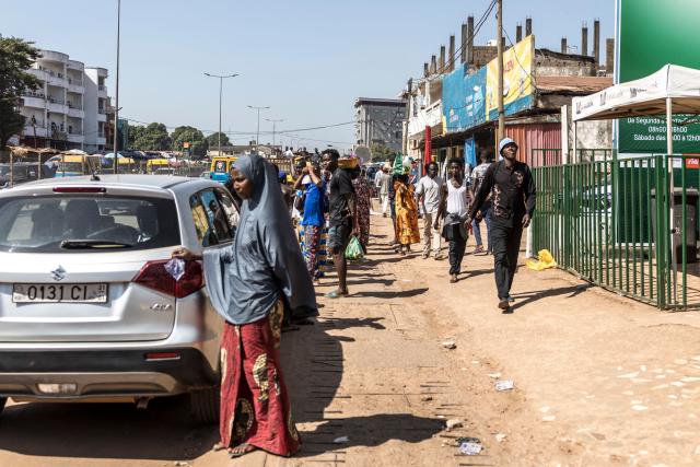 Pedestrians walk at a market in Bissau, on November 28, 2025. Life limped back to normal on Friday in the capital of volatile Guinea-Bissau after the west African nation's fifth coup that came on the heels of presidential and parliamentary polls.
The military appointed General Horta N'Tam, the army's chief of staff, as the country's new leader for a transition period of one year after Wednesday's putsch. The takeover came just one day before authorities had been due to announce the provisional results of the November 23 polls. There were vehicles and taxis along the main road from the port of the seaside capital Bissau to the presidential palace, as well as pedestrians (Photo by PATRICK MEINHARDT / AFP)