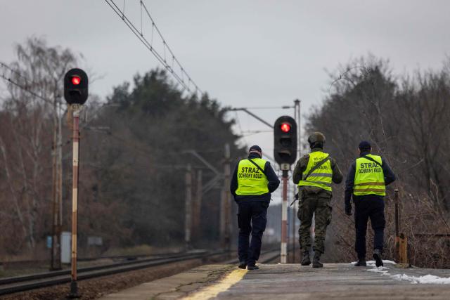 Two guards of the Railway Security Guard and a soldier of the Territorial Defense Forces patrol the area along the railroad tracks in the suburbs of Warsaw on November 27, 2025. The patrol is a part of "Operation Horizon," an effort launched by Poland earlier this month designed to boost rail security and protect critical infrastructure, following a series of diversions, which officials blame on Russia. (Photo by Wojtek RADWANSKI / AFP)