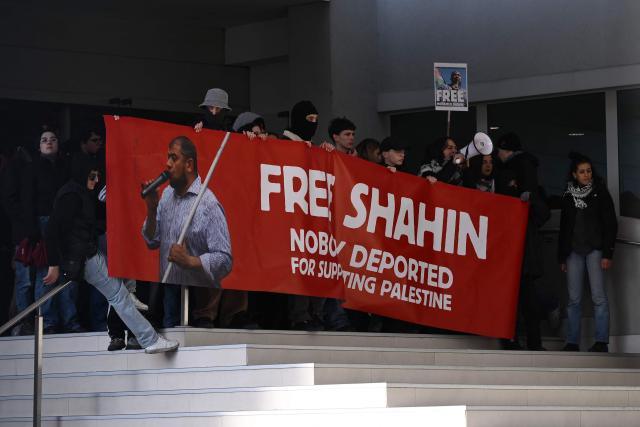 Protesters hold a banner “Free Mohamed Shahin”, one of the Imam of Turin detained in Italy, inside the editorial office of newspapers La Stampa and Repubblica during a nationwide strike organized by the Unione Sindacale di Base (USB Union), in Turin on November 28, 2025. Trade unions have called a strike for public and private sector workers, affecting transport, schools, healthcare, and other public services. The reasons behind the strike are linked to the 2026 Economic Plan, which is being contested by the union groups CUB, USB, SGB, COBAS, and USI-CIT, who oppose the increase in military spending at the expense of essential public services. (Photo by MARCO BERTORELLO / AFP)