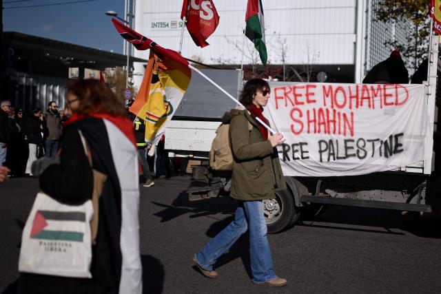 Protesters hold a banner “Free Mohamed Shahin”, one of the Imam of Turin detained in Italy, during a nationwide strike organized by the Unione Sindacale di Base (USB Union), in Turin on November 28, 2025. Trade unions have called a strike for public and private sector workers, affecting transport, schools, healthcare, and other public services. The reasons behind the strike are linked to the 2026 Economic Plan, which is being contested by the union groups CUB, USB, SGB, COBAS, and USI-CIT, who oppose the increase in military spending at the expense of essential public services. (Photo by MARCO BERTORELLO / AFP)