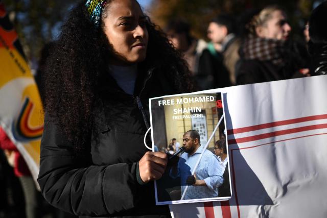 A woman holds a poster “Free Mohamed Shahin” one of the Iman of Turin detained in Italy, during a nationwide strike organized by the Unione Sindacale di Base (USB Union) in Turin, northwestern Italy on November 28, 2025. Trade unions have called a strike for public and private sector workers, affecting transport, schools, healthcare, and other public services. The reasons behind the strike are linked to the 2026 Economic Plan, which is being contested by the union groups CUB, USB, SGB, COBAS, and USI-CIT, who oppose the increase in military spending at the expense of essential public services. (Photo by MARCO BERTORELLO / AFP)