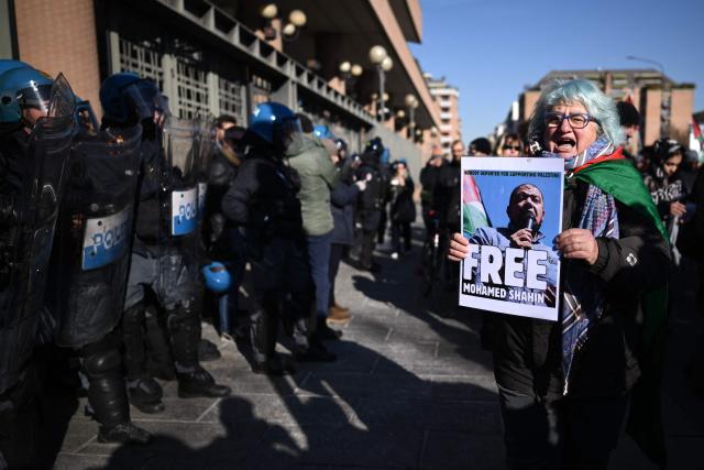 A woman holds a poster “Free Mohamed Shahin” one of the Iman of Turin detained in Italy, during a nationwide strike organized by the Unione Sindacale di Base (USB Union) in Turin, northwestern Italy on November 28, 2025. Trade unions have called a strike for public and private sector workers, affecting transport, schools, healthcare, and other public services. The reasons behind the strike are linked to the 2026 Economic Plan, which is being contested by the union groups CUB, USB, SGB, COBAS, and USI-CIT, who oppose the increase in military spending at the expense of essential public services. (Photo by MARCO BERTORELLO / AFP)