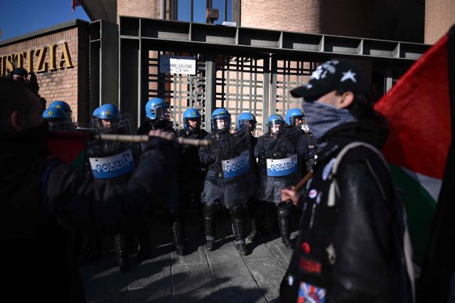 Students face police near the Justice Palace during a nationwide strike organized by the Unione Sindacale di Base (USB Union) in Turin, northwestern Italy on November 28, 2025. Trade unions have called a strike for public and private sector workers, affecting transport, schools, healthcare, and other public services. The reasons behind the strike are linked to the 2026 Economic Plan, which is being contested by the union groups CUB, USB, SGB, COBAS, and USI-CIT, who oppose the increase in military spending at the expense of essential public services. (Photo by MARCO BERTORELLO / AFP)
