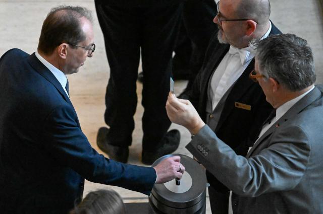 German Interior Minister Alexander Dobrindt (L) casts his vote during a general debate on the federal budget 2026 at the Bundestag, Germany's lower house of parliament in Berlin on November 26, 2025. (Photo by Tobias SCHWARZ / AFP)