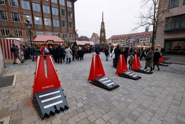 Mobile vehicle mitigation barriers are seen near the Christmas market prior to its official opening in Nuremberg, Germany on November 28, 2025. Christmas markets are a beloved tradition in Germany, with nearly every small town boasting its own, where merchants peddle gifts, hot mulled wine, sausages and sweets. But the mounting costs and complexity of ensuring security after the 2024 attack in Magdeburg, and a 2016 truck rampage in Berlin, have cast some of the markets into doubt. (Photo by Alexandra BEIER / AFP)