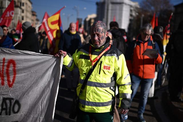 People march during a nationwide strike organized by the Unione Sindacale di Base (USB Union) in Turin, northwestern Italy on November 28, 2025. Trade unions have called a strike for public and private sector workers, affecting transport, schools, healthcare, and other public services. The reasons behind the strike are linked to the 2026 Economic Plan, which is being contested by the union groups CUB, USB, SGB, COBAS, and USI-CIT, who oppose the increase in military spending at the expense of essential public services. (Photo by MARCO BERTORELLO / AFP)