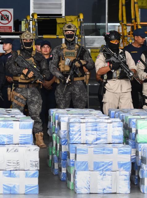 Costa Rican police stand guard next cocaine packs in Alajuela, Costa Rica on November 28, 2015. Costa Rican police, supported by the US Coast Guard, seized more than four tons of cocaine in the Pacific, in an operation that authorities described as "historic". (Photo by EZEQUIEL BECERRA / AFP)