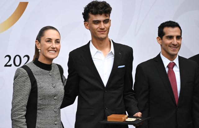 Mexican cyclist Isaac del Toro (C) poses with President Claudia Sheinbaum and the Director of the National Commission for Physical Culture and Sport Rommel Pacheco after receiving the National Sports Award during a ceremony at the National Palace in Mexico City on November 28, 2025. (Photo by Yuri CORTEZ / AFP)