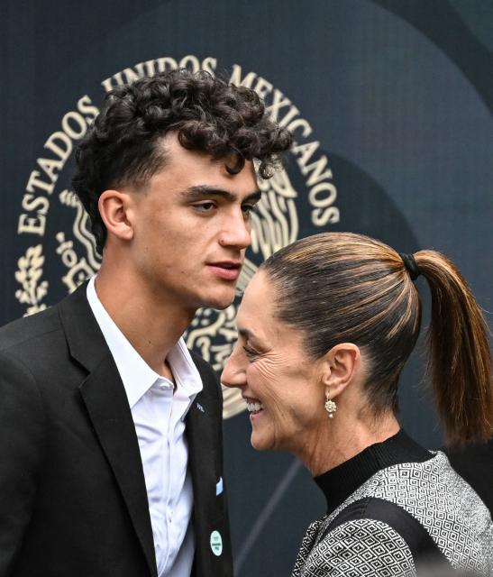 Mexican cyclist Isaac del Toro crosses with Mexico's President Claudia Sheinbaum before  receiving the National Sports Award during a ceremony at the National Palace in Mexico City on November 28, 2025. (Photo by Yuri CORTEZ / AFP)