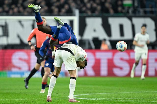 Leipzig's French defender #23 Castello Lukeba (top) and Moenchengladbach's Bosnian-Swiss forward #15 Haris Tabakovic vie for the ball during the German first division Bundesliga football match between Borussia Moenchengladbach and RB Leipzig in Moenchengladbach, western Germany on November 28, 2025. (Photo by INA FASSBENDER / AFP) / DFL REGULATIONS PROHIBIT ANY USE OF PHOTOGRAPHS AS IMAGE SEQUENCES AND/OR QUASI-VIDEO