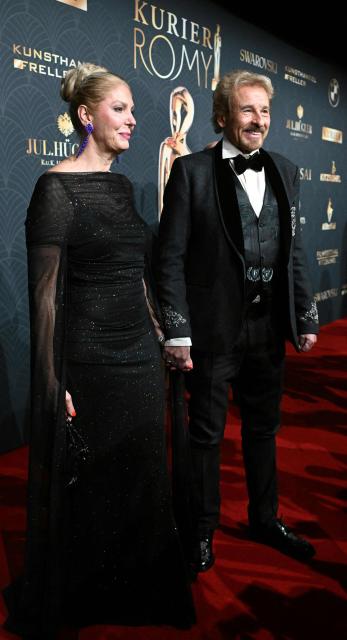 German host and entertainer Thomas Gottschalk and wife Karina Mross arrive on the red carpet to attend the award ceremony of the Kurier Romy Gala in Kitzbühel, Austria on November 28, 2025. (Photo by BARBARA GINDL / APA / AFP) / Austria OUT