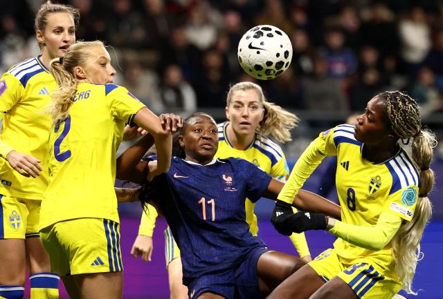France's midfielder #11 Kadidiatou Diani (C) fights for the ball with Sweden's forward #08 Evelyn Ijeh (R) and Sweden's defender #02 Smilla Holmberg (L) during the Women's Nations League third place playoff first leg football match between France and Sweden at Auguste-Delaune stadium in Reims, on November 28, 2025. (Photo by FRANCK FIFE / AFP)