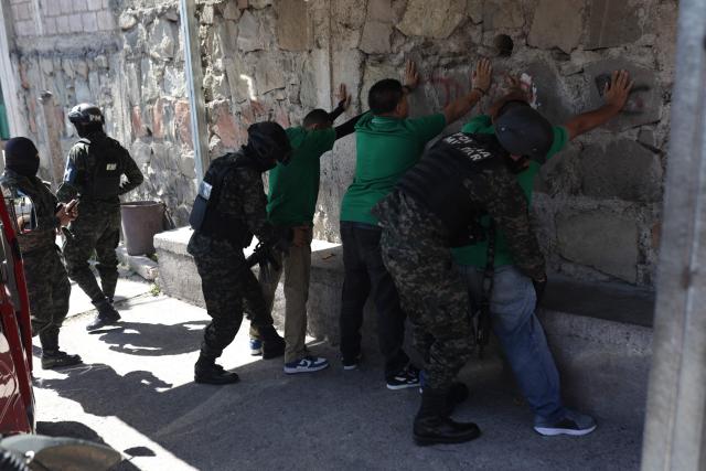 Military police officers frisk people during a security operation ahead of the presidential elections in the surroundings of Tegucigalpa on November 28, 2025. Honduras will hold presidential elections on November 30. (Photo by Lucas AGUAYO / AFP)