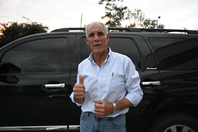 Honduran presidential candidate and businessman Nasry Asfura of the opposition National Party gives a thumbs-up as he leaves after a meeting with business leaders in Tegucigalpa on November 28, 2025. Asfura told AFP that he has "no connection whatsoever" with former president Juan Orlando Hernandez, who is imprisoned in the United States on drug trafficking charges and was pardoned on Friday by President Donald Trump. (Photo by Orlando SIERRA / AFP)