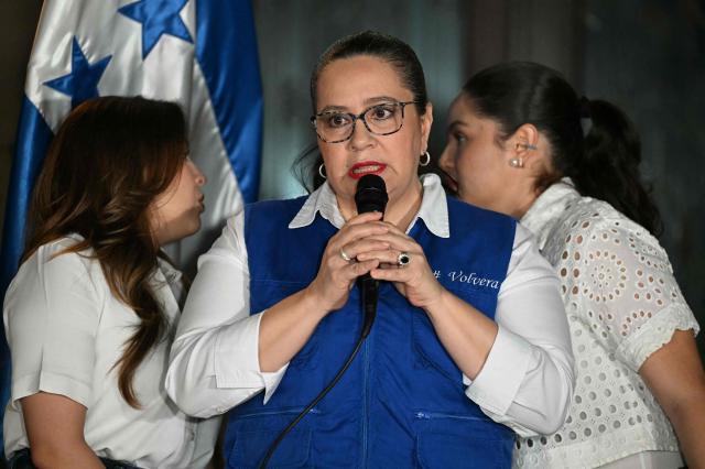 Ana Garcia de Hernandez (C), wife of former Honduras President Juan Orlando Hernandez, talks to the media during a press conference in Tegucigalpa on November 28, 2025. US President Donald Trump said Friday he will pardon Honduran ex-president Juan Orlando Hernandez, who was convicted of drug trafficking and sentenced to 45 years in prison in the US. (Photo by Marvin RECINOS / AFP)