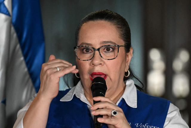 Ana Garcia de Hernandez (C), wife of former Honduras President Juan Orlando Hernandez, talks to the media during a press conference in Tegucigalpa on November 28, 2025. US President Donald Trump said Friday he will pardon Honduran ex-president Juan Orlando Hernandez, who was convicted of drug trafficking and sentenced to 45 years in prison in the US. (Photo by Marvin RECINOS / AFP)